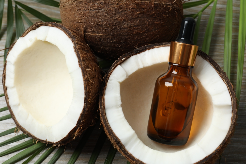 Skin care with facial serum. Glass bottle with pipette on a wooden background. Dry skin care product. Coconut essential oil moisturizing the skin of the body