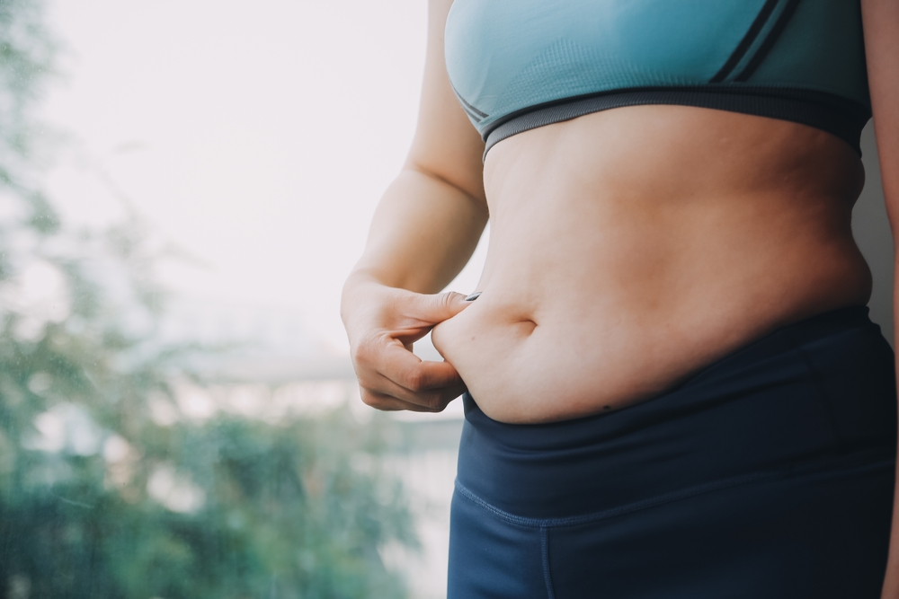 fat woman, fat belly, chubby, obese woman hand holding excessive belly fat with measure tape, woman diet lifestyle concept