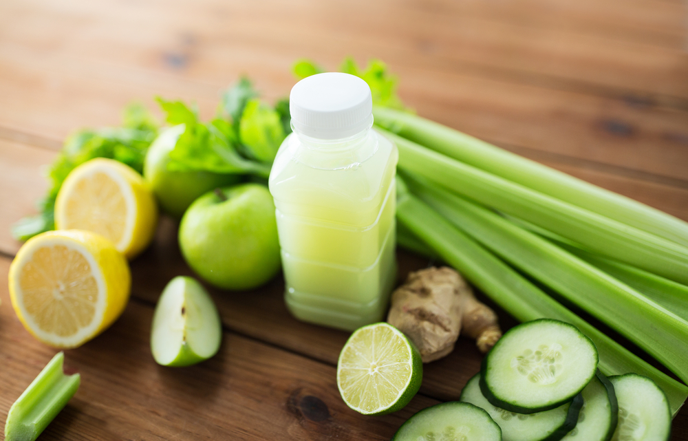 healthy eating, food, dieting and vegetarian concept - bottle with green juice, fruits and vegetables on wooden table

