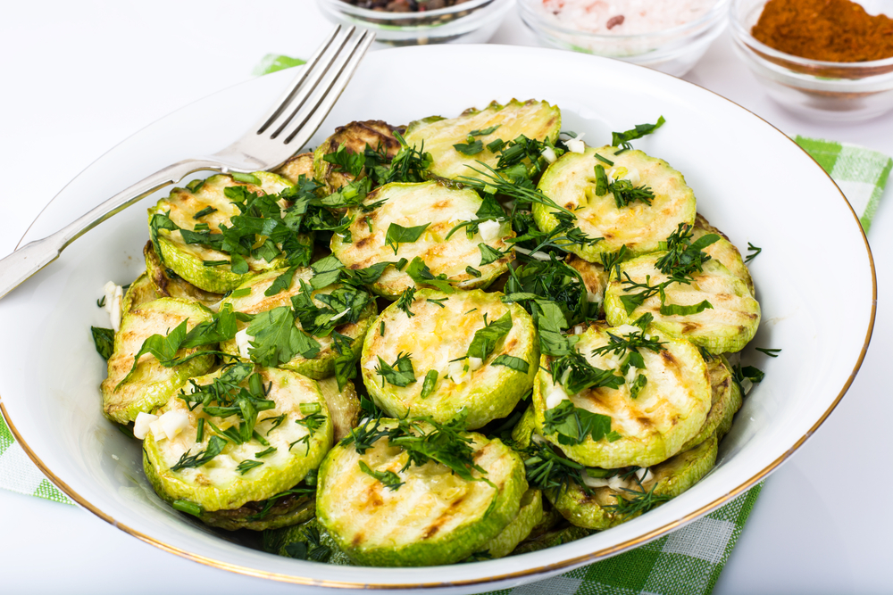 Fried zucchini with herbs and garlic. Studio Photo.

