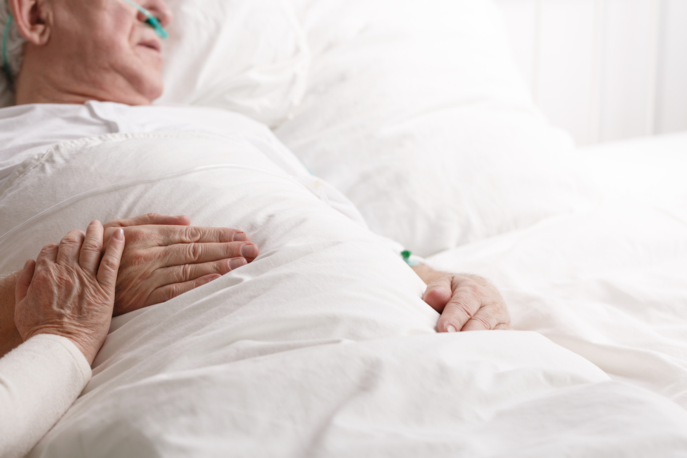 Sick senior man laying in hospital bed 