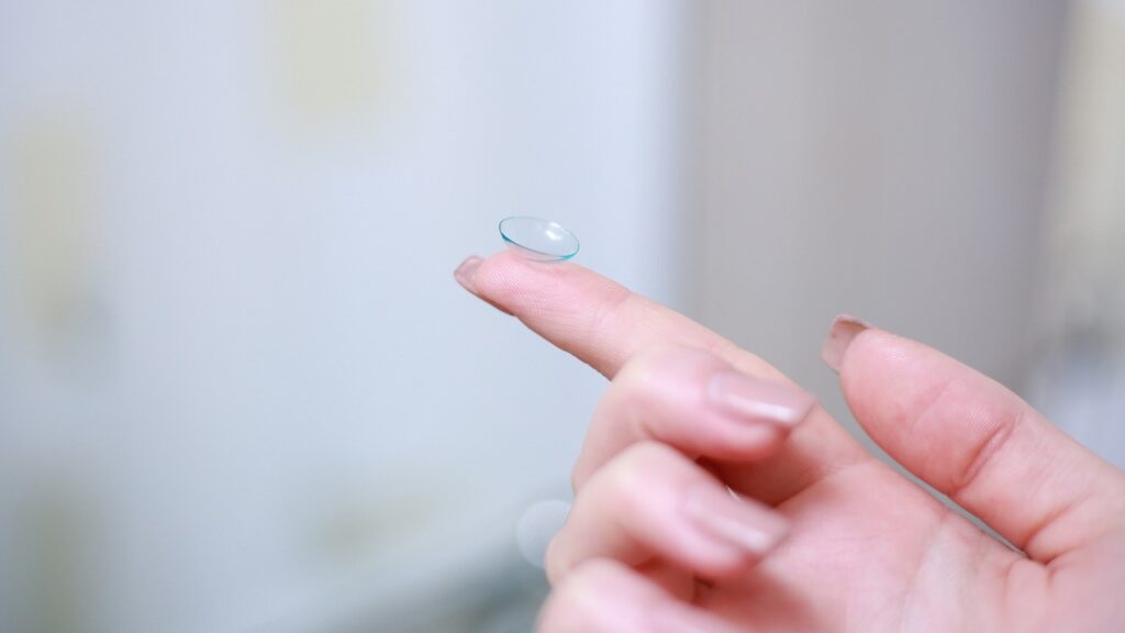 A contact lense on a finger. Blurred background. 