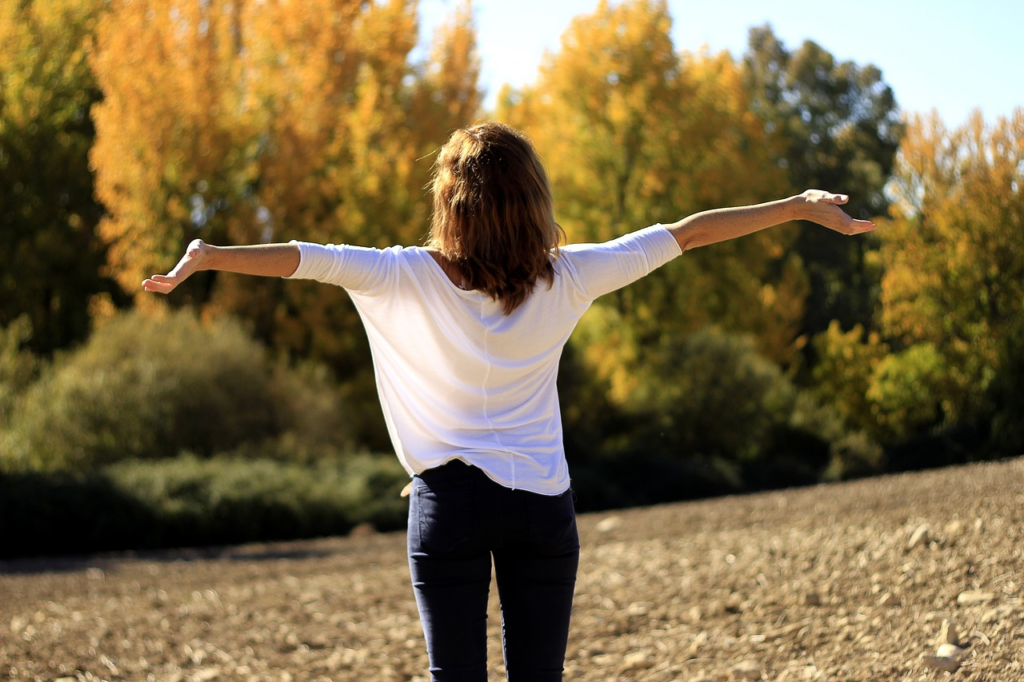 woman with her arms open outside