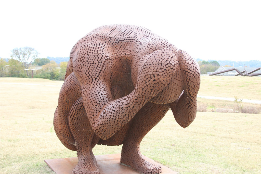 statue of someone crouching and holding their head