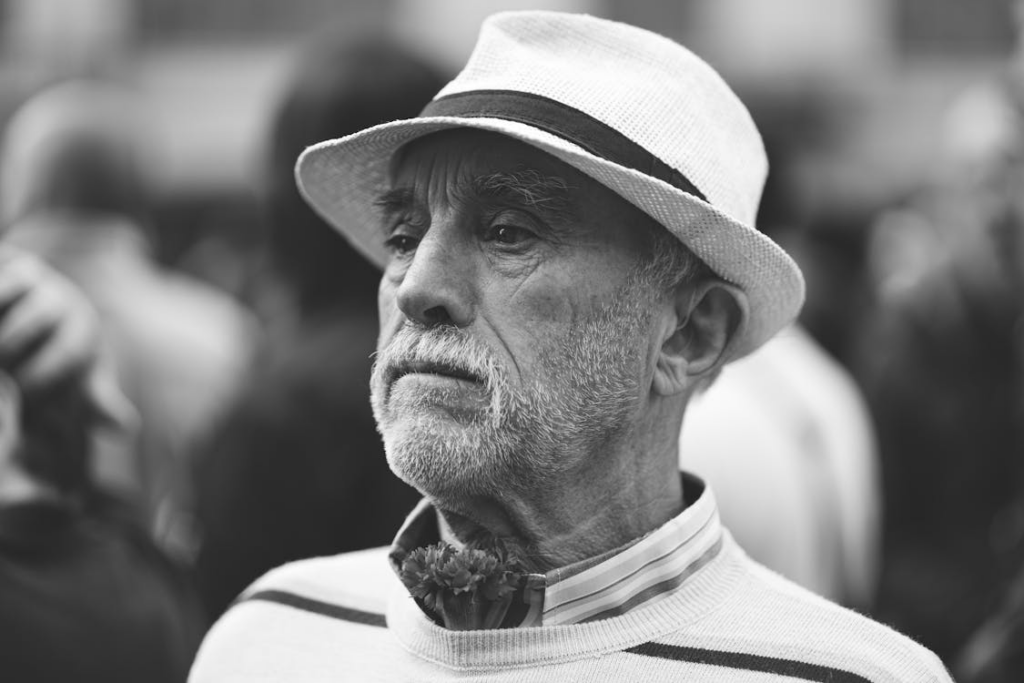 Candid Portrait of an Elderly Man Standing among the Crowd