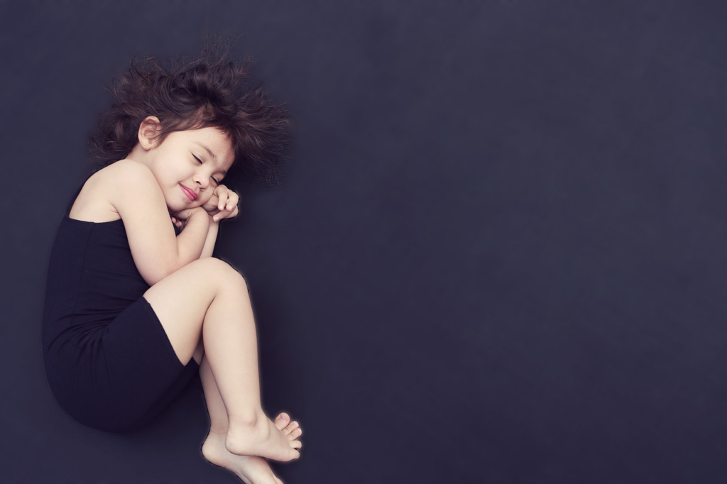 little girl sleeping curled up on the floor