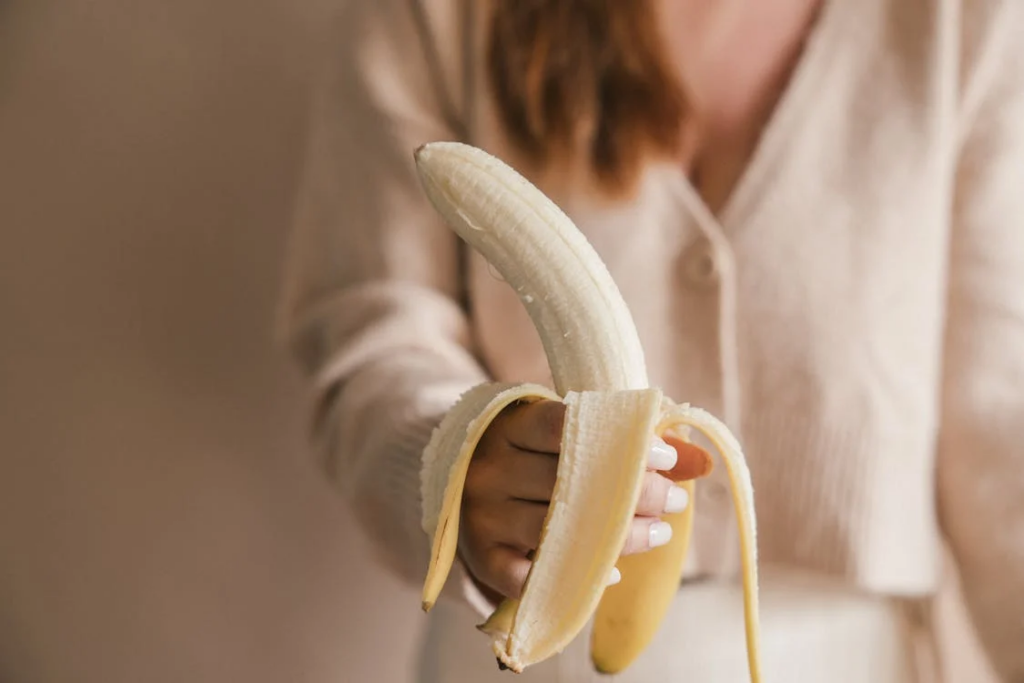 woman holding peeled banana
