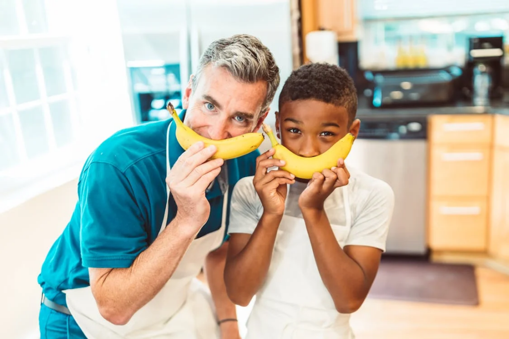 man and boy smiling with bananas