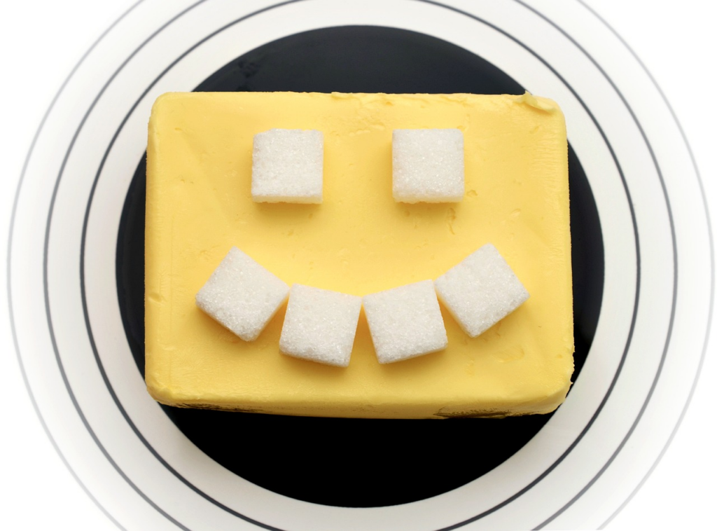 square of butter with sugar cubes on top making a smiley face