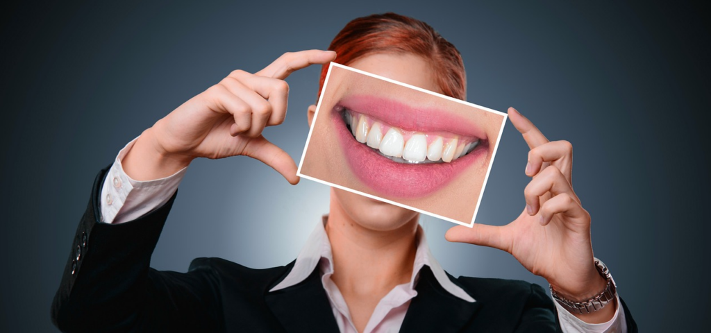 woman holding a photo of a smile in front of her face