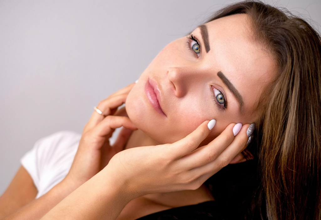 woman gently touching her face