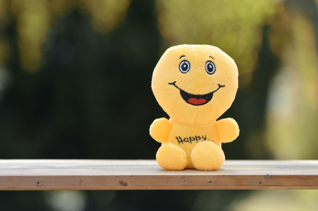 happy plushie on a railing