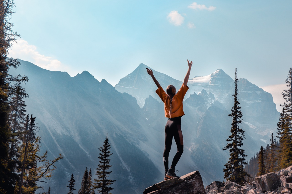 woman on a trail with her arms up