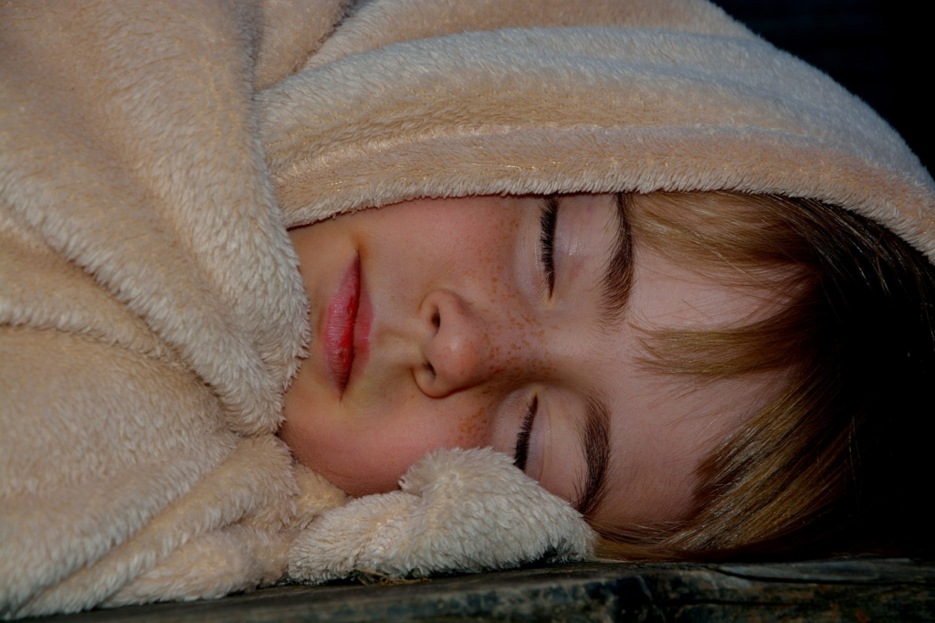 child wrapped up sleeping in a blanket