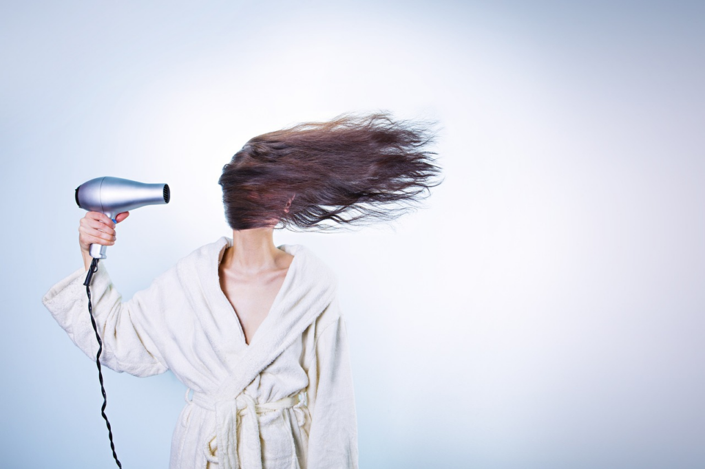 woman blow drying her hair