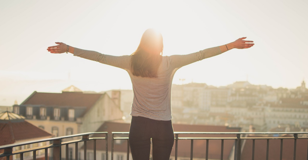 woman in the sunshine with her arms open