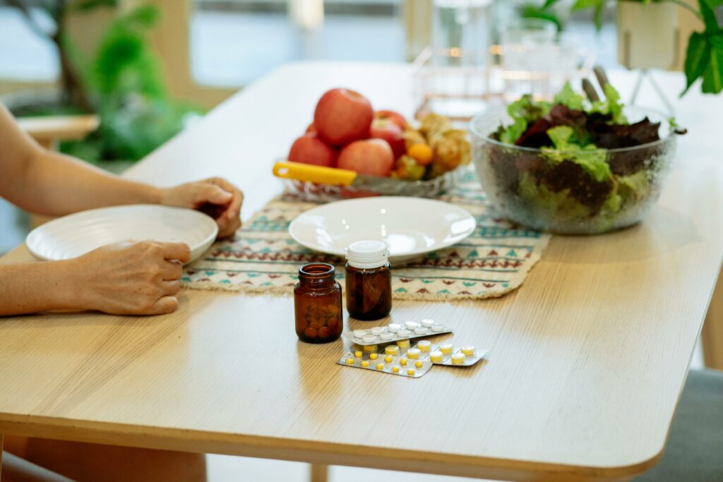 Medicament and fresh fruits and veggies placed on table