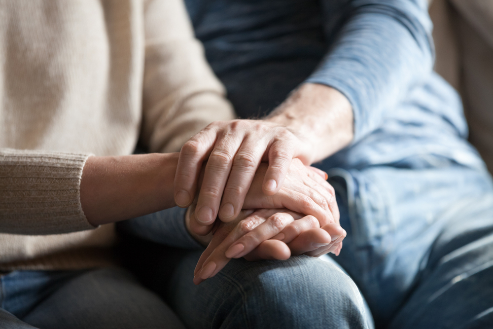 Close up view of mature couple holding hands, loving caring elderly man supporting senior middle aged woman giving psychological empathy and understanding in marriage, getting older together concept