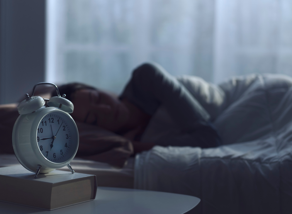 Young african woman sleeping in her bed at night, she is resting with eyes closed
