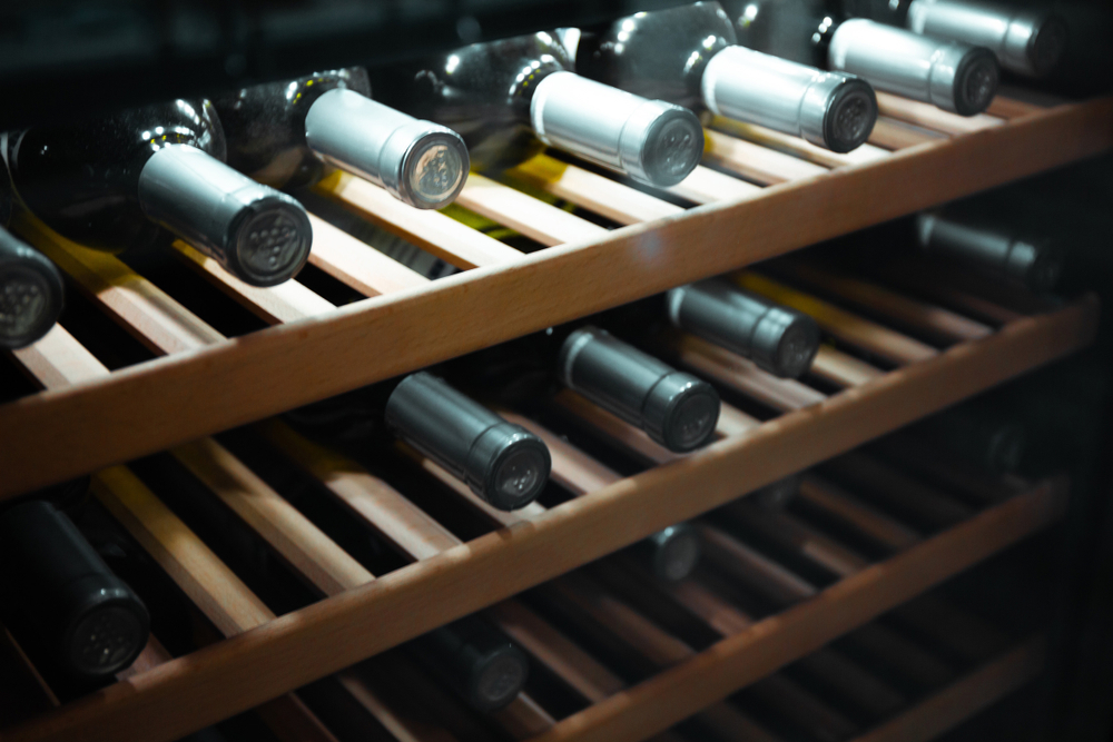 Storing bottles of wine in fridge. Alcoholic card in restaurant. Cooling and preserving wine.