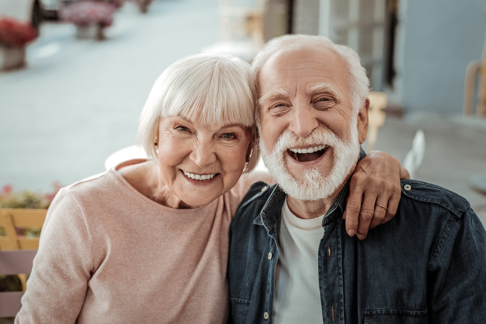 Nurse in retirement home helping old male patient with board game. Senior man with cognitive disorder sitting at table in geriatric clinic, playing games and thinking. Dementia, Alzheimers, care