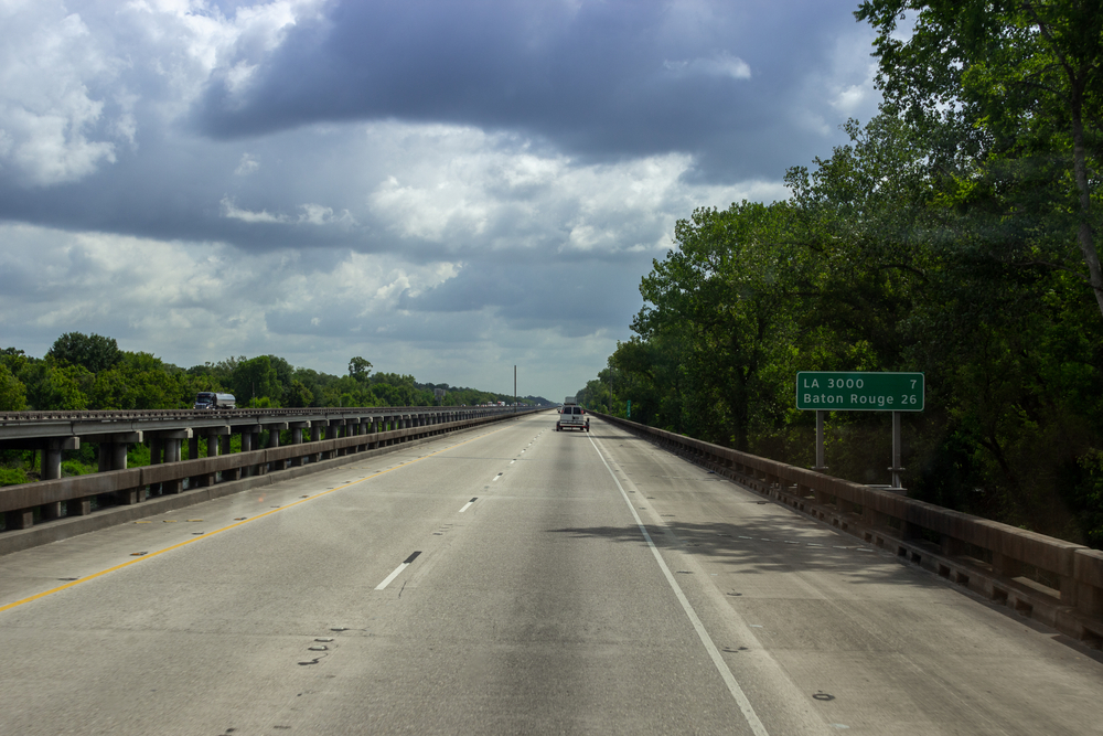 The road, a long bridge on which cars ride on a sunny summer day. Summer on the roads of Louisiana, USA. Interstate 10
