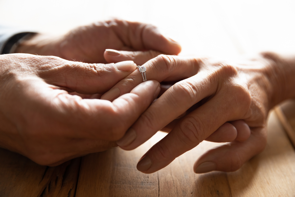 Close up view of mature couple holding hands, loving caring elderly man supporting senior middle aged woman giving psychological empathy and understanding in marriage, getting older together concept
