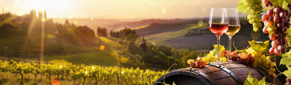 Glass Of Wine With Grapes And Barrel On A Sunny Background. Italy Tuscany Region