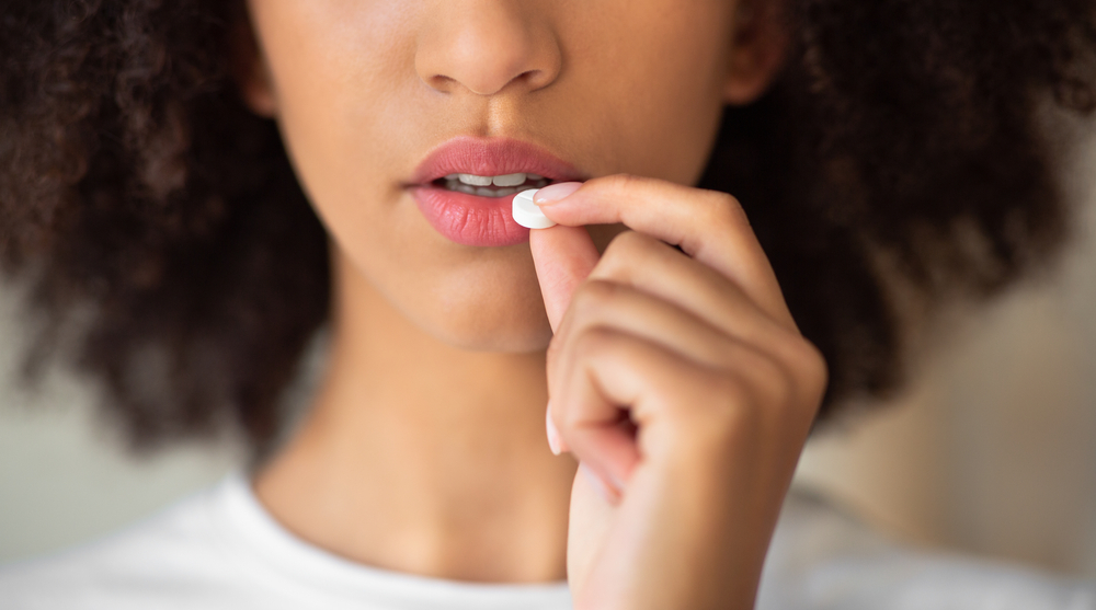 Ill, menstruation, contraceptive and daily dose of medications. Feeling unwell, suffering from headache desperate millennial african american lady taking pill, cropped, close up, panorama, copy space