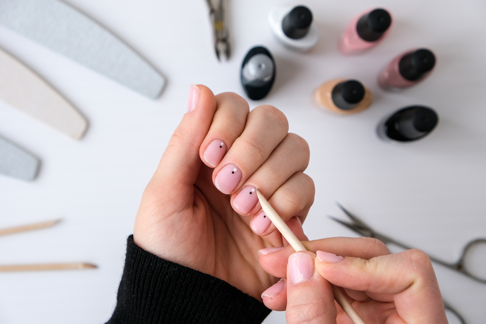 Woman hands, nail polish, manicure tools table top view flat lay. How to do manicure at home concept. Do manicure by yourself staying at home. Self care. Nude nails. Spa, medicine advertisement.