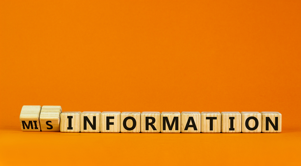 Information or misinformation symbol. Turned cubes and changed the word misinformation to information. Orange background, copy space. Business and information or misinformation concept.