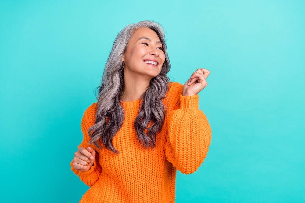 Profile side photo of mature cheerful pretty lady have fun clubber look empty space isolated over turquoise color background