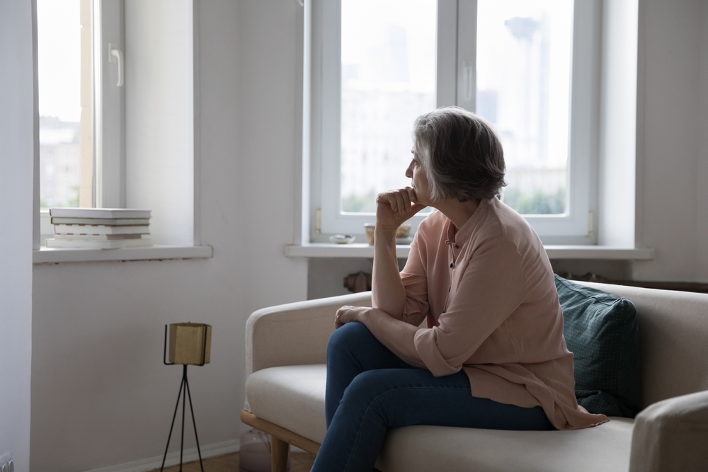 Sad lonely mature grey haired lady looking at window away, thinking over health problems, loneliness, bad news, loss, suffering from apathy, mourning depression. Frustrated middle aged woman at home
