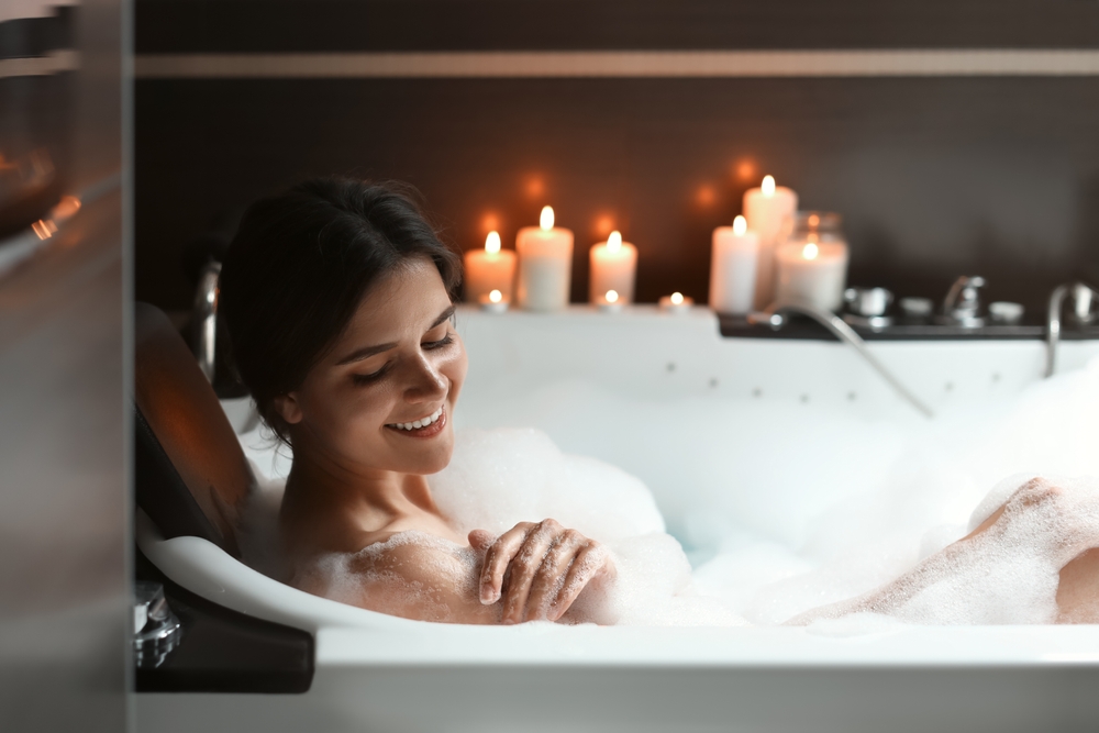 Happy beautiful woman taking bubble bath. Romantic atmosphere