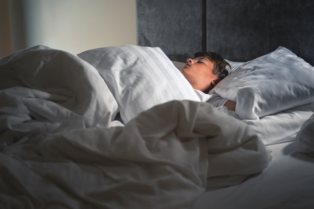 A boy sleeps in his bed.A real scene of sleep and rest