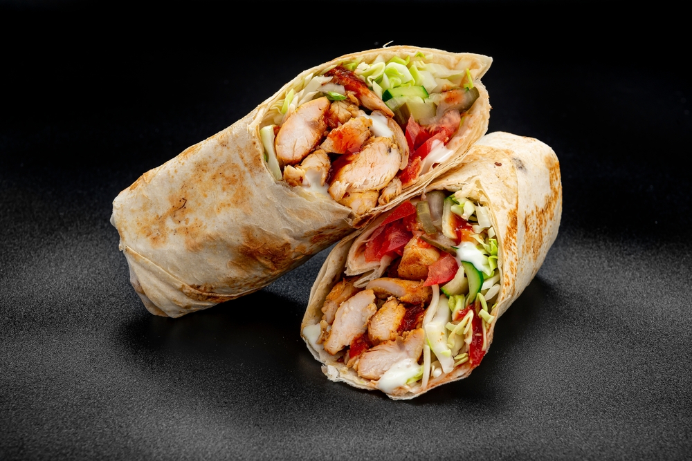 Beef shawarma on a dark background. Shawarma with beef in pita bread. Photo for the menu