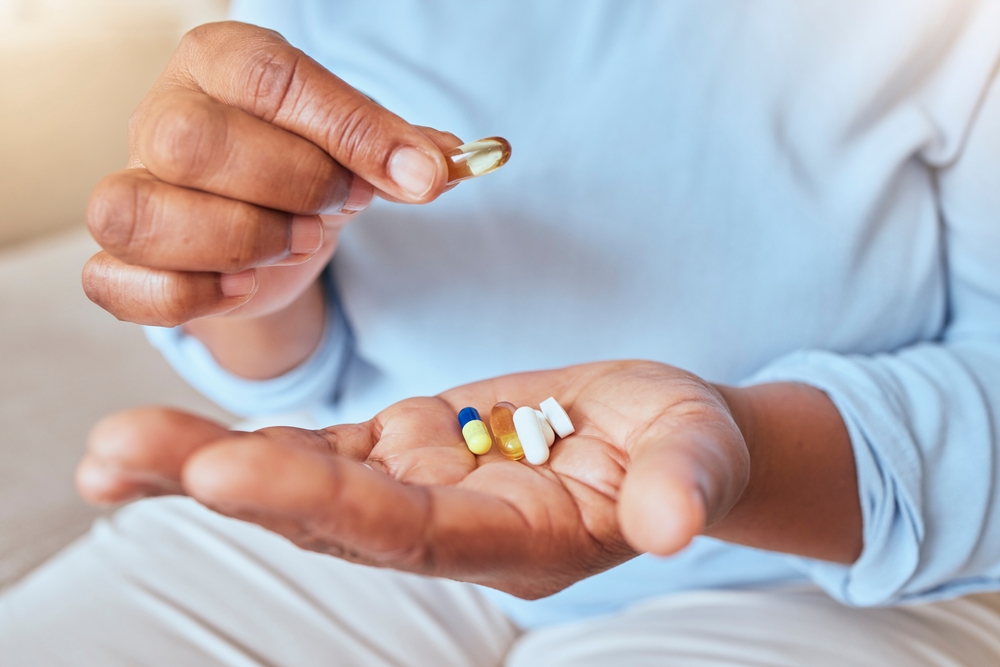 Health, wellness and pills in hand for medicine self care of black woman for pharmaceutical routine. Drugs, supplement and healthy chronic medication for vitality lifestyle of lady with hands zoom.