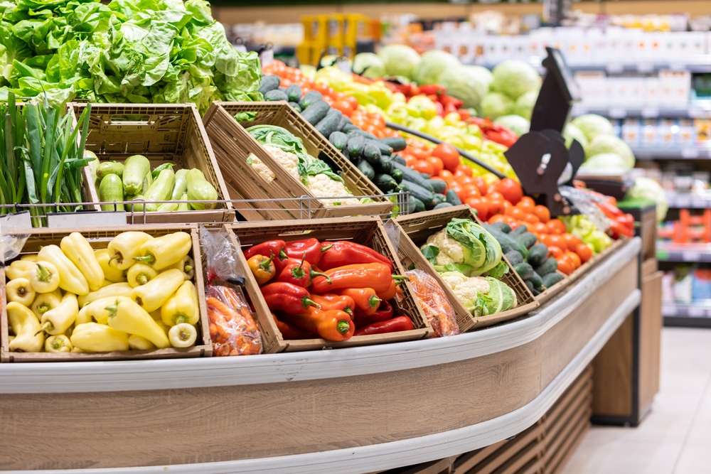 Supermarket showcase with wooden boxes of vegetables. Organic fresh broccoli, paprika, lettuce, onion. Concept of bio food and shopping in grocery store.
