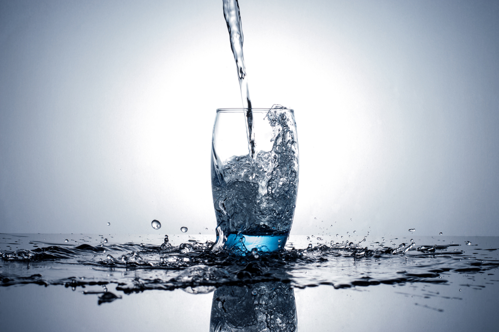 Water flowing and splashing into a glass
