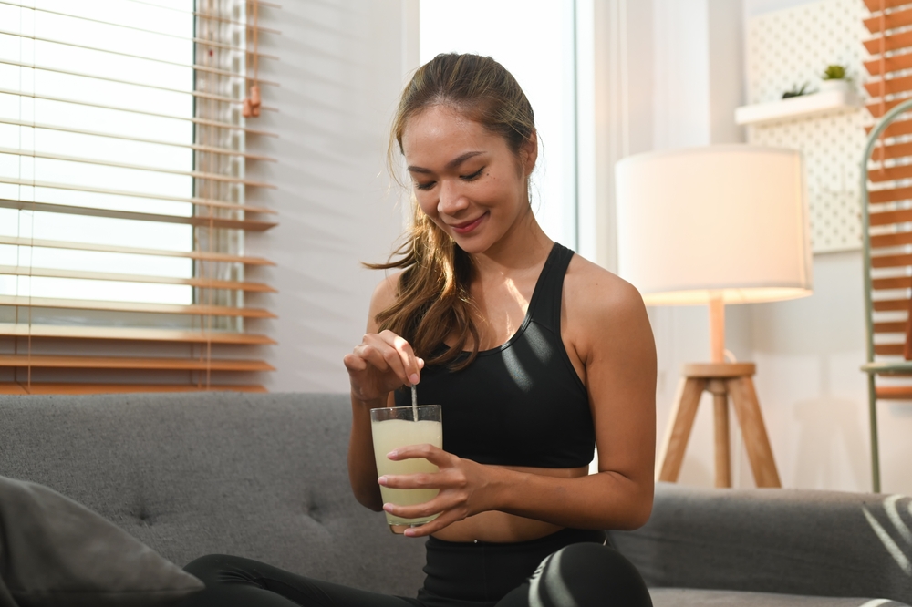 Attractive woman drinking collagen supplements for skin, hair and nail strengthen. Dietary supplement, healthcare concept
