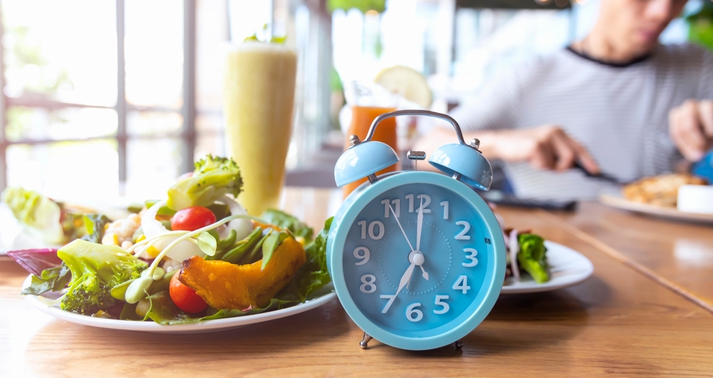 Blue alarm clock with IF (Intermittent Fasting) 16 and 8 diet rule and weight loss concept.-Diet plan concept