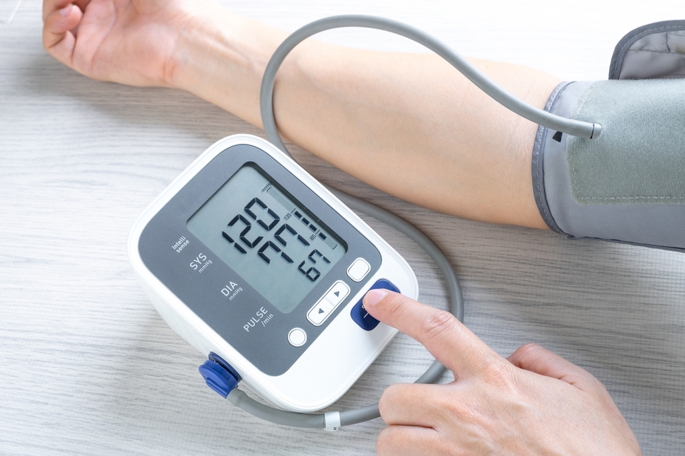 Man checks blood pressure monitor and heart rate monitor with digital pressure gauge. Health care and Medical concept.
