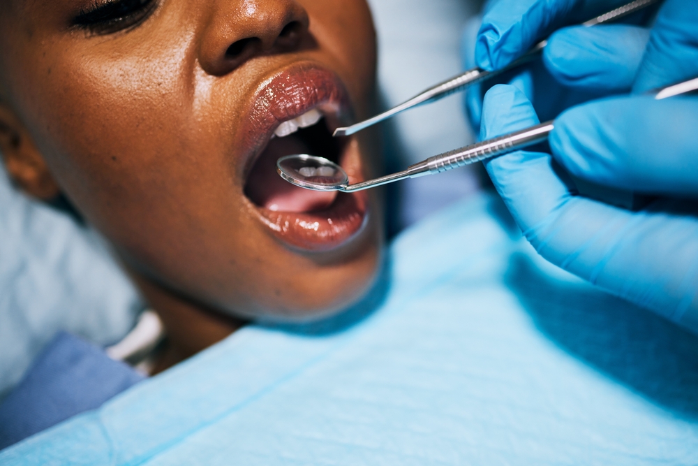 Mouth, woman and hands of dentist in dental surgery for clean teeth, denchers or oral hygiene at clinic. Female in tooth whitening treatment with tools for cleaning gum bacteria, disease or decay
