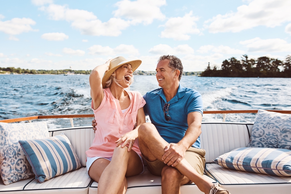Laughing, happy couple and on a boat for retirement travel, summer freedom and holiday in Bali. Smile, love and a senior man and woman on a yacht for vacation adventure, luxury and a cruise date
