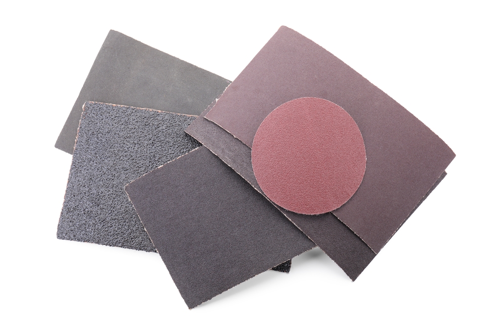 Many sheets of sandpaper isolated on white, top view