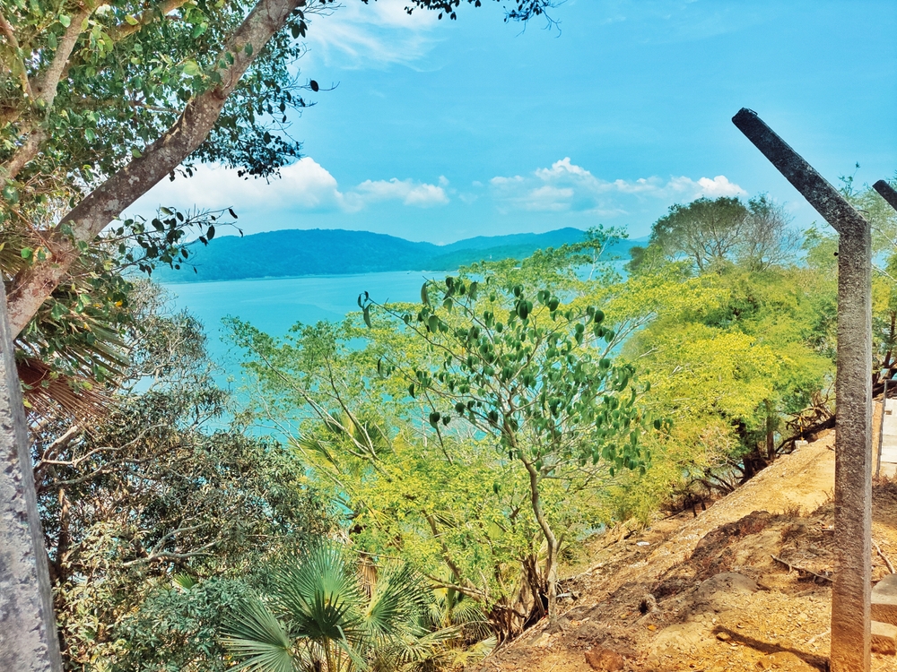 Andaman Nicobar Islands, India 1st April 2023: A scenic view of Ross Islands with trees blue water ,sky and blurred mountain background
