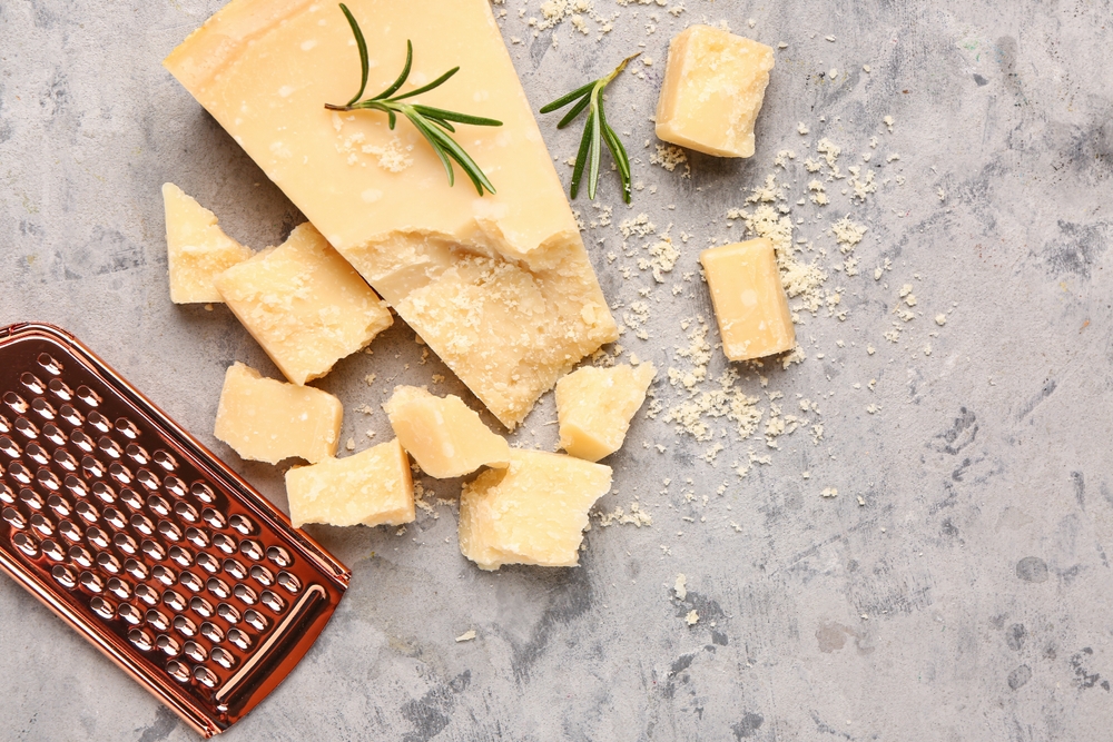 Pieces of tasty Parmesan cheese on grunge background
