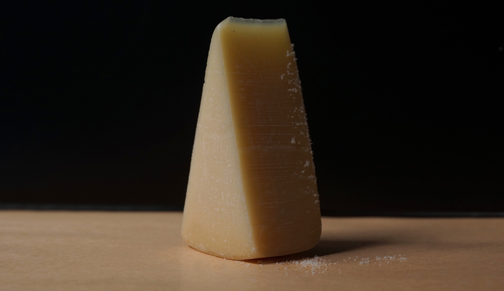 Parmesan. Piece of cheese on the table. Shredded Parmesan cheese
