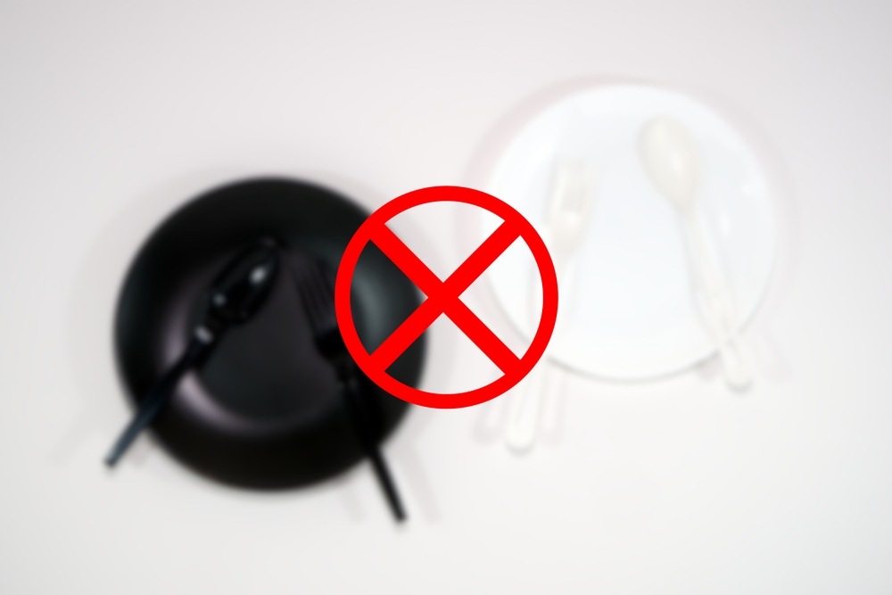 Black and white plate with cutlery set blurred image with ban or not allowed sign on foreground, Food concept photography