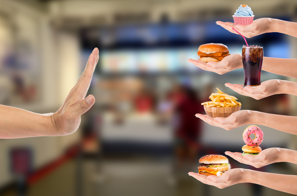 Hand refusing junk food with white background